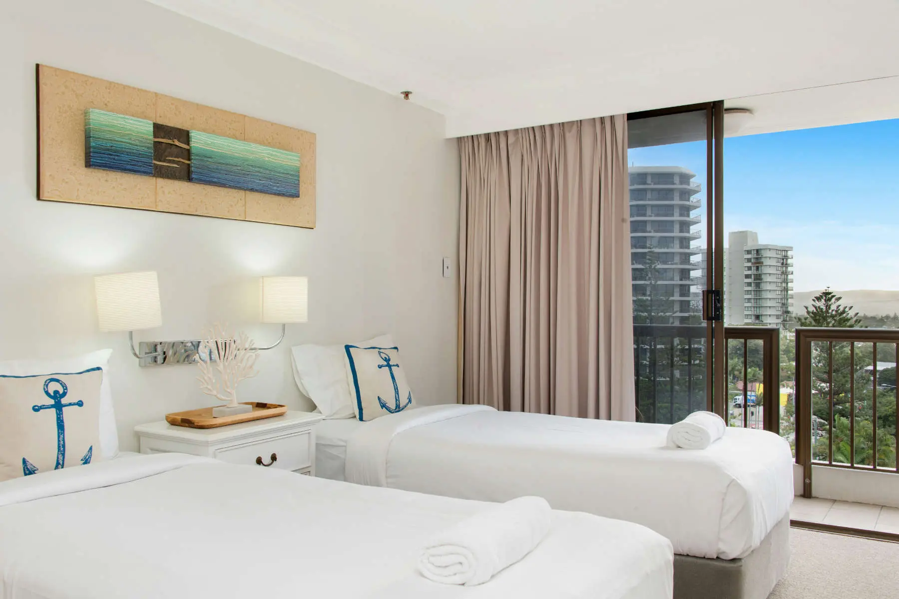 Habitació d'apartament turístic amb dos llits fets i vistes al mar