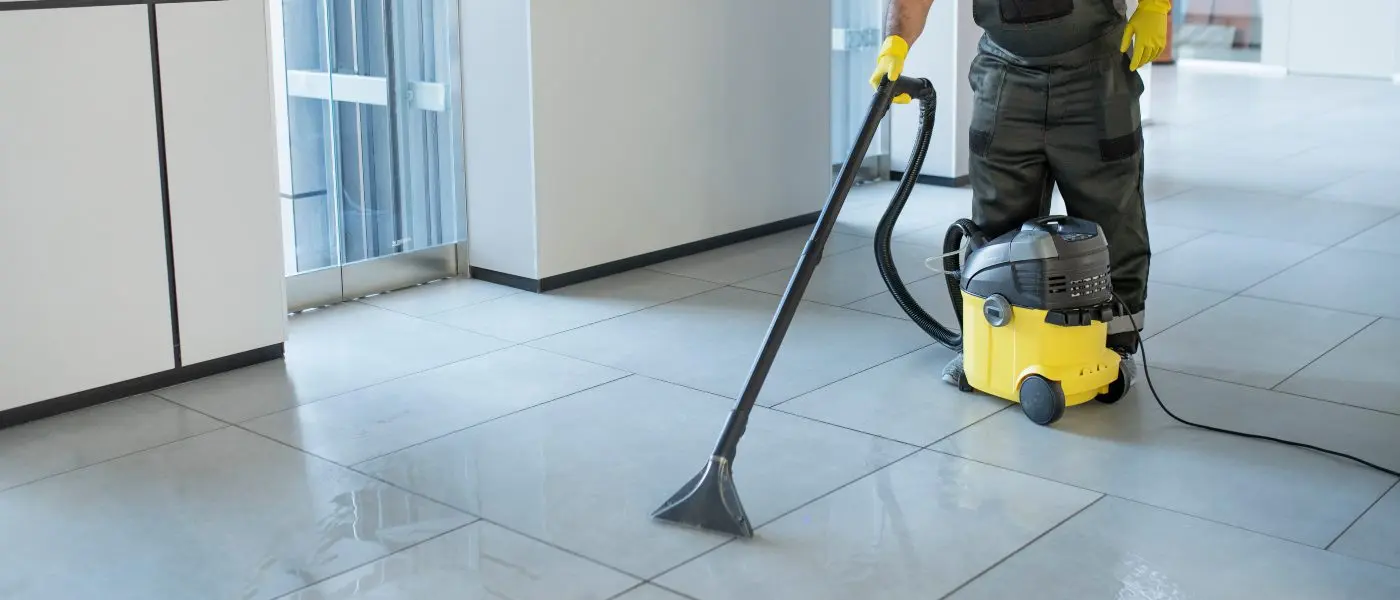 Operari aspirant el terra d'un replà amb una aspiradora industrial