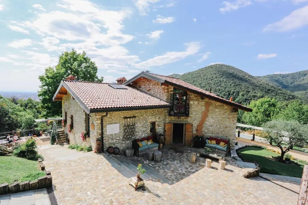 Casa de pedra amb jardí i muntanyes al fons